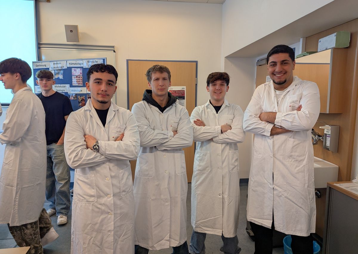 Schüler in Laborkitteln im medizinischen Labor